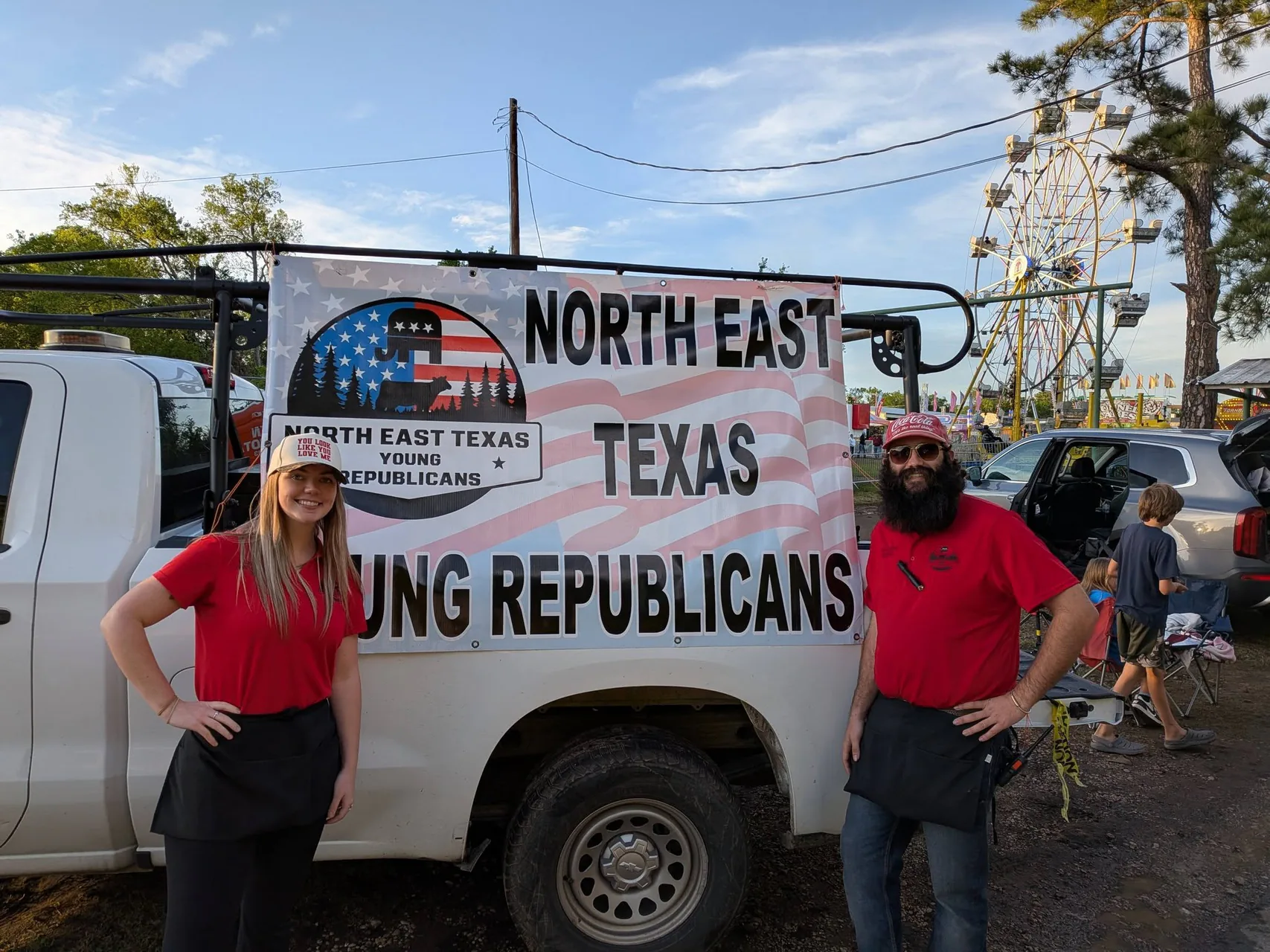 NETYR volunteers stand beside the organization's event banner at a community fair.
